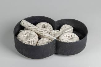 Black Vessel with Pierced White Forms